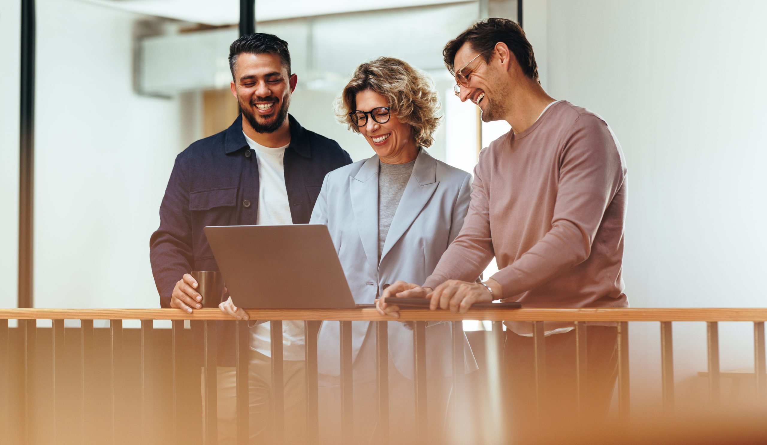 Zufriedene Geschäftsleute, die über ihren Laptop mit ihren Geschäftspartnern videotelefonieren. Eine Gruppe von Designern, die beieinander steht und ein Online-Meeting abhält. Ein kreatives Geschäftsteam, das in einem Start-up arbeitet.